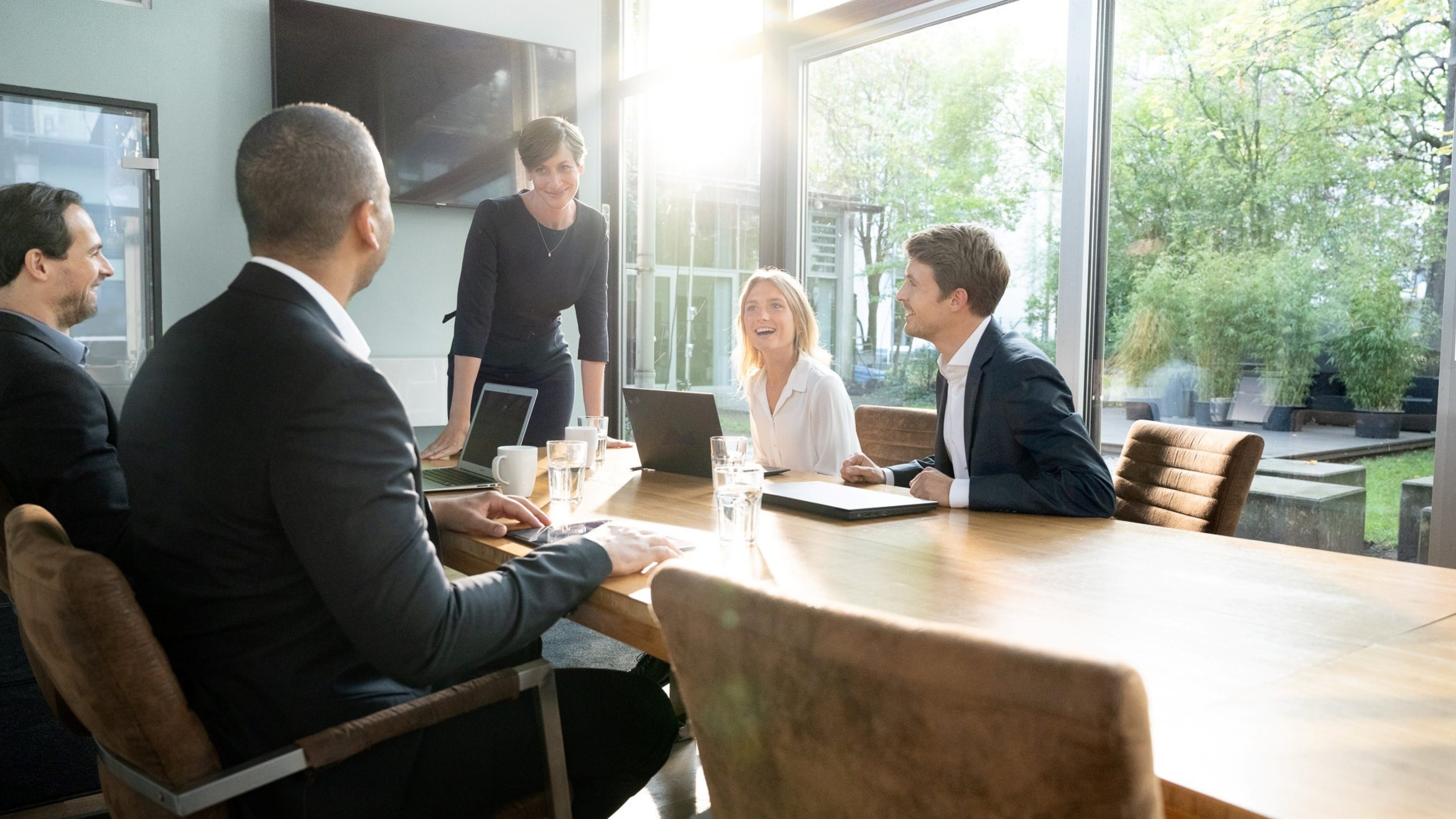 Group of people sitting and laughing around a meeting table